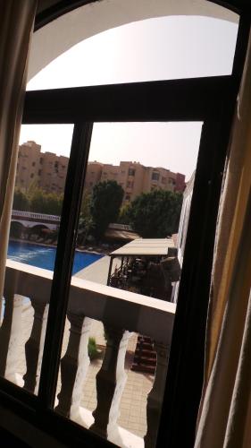 a view of a swimming pool from a window at Targafit Hotel & Hammam in Marrakech