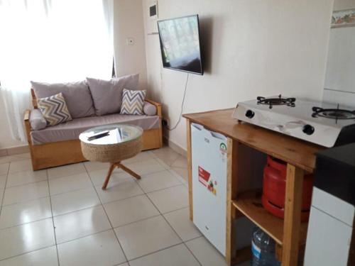 a small living room with a couch and a kitchen at Truthvacay in Mombasa