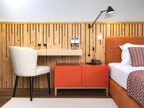 a bedroom with a bed and a desk and a chair at Central Monchique Hotel - Villa Termal Spa Resort - by Unlock Hotels in Monchique