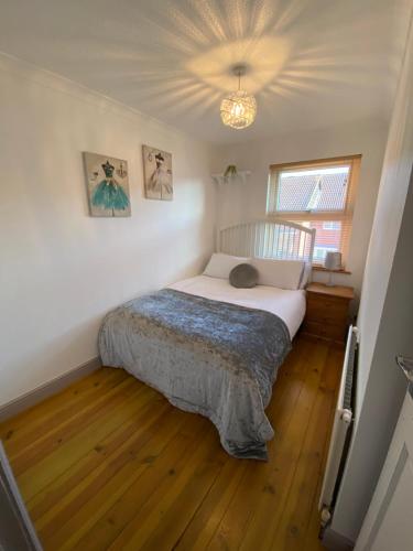 um quarto com uma cama num quarto com pisos em madeira em Bluebell Place em Chelmsford