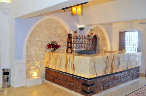 a bar in a building with a stone wall at Hôtel Djerba Authentique - Au centre de Midoun in Midoun