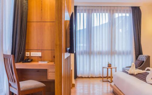 a bedroom with a desk and a bed and a desk and a window at Pelyang Boutique in Thimphu