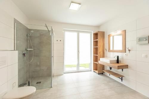 a bathroom with a shower and a toilet and a sink at Inzell Chalets by ALPS RESORTS in Inzell