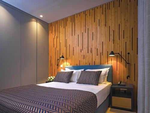 a bedroom with a bed with a wooden wall at Central Monchique Hotel - Villa Termal Spa Resort - by Unlock Hotels in Monchique