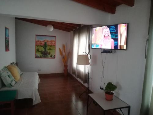 a living room with a flat screen tv on the wall at El Pesebre in Cachí