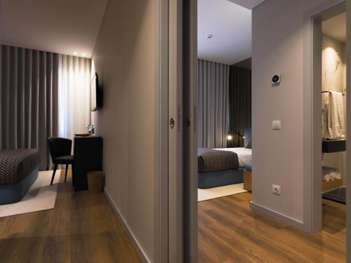 a bedroom with a bed and a room with a mirror at Central Monchique Hotel - Villa Termal Spa Resort - by Unlock Hotels in Monchique