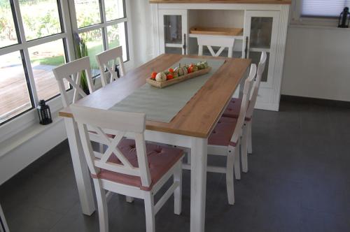 una mesa de madera con sillas y un bol de fruta. en Kleiner Onkel en Twist