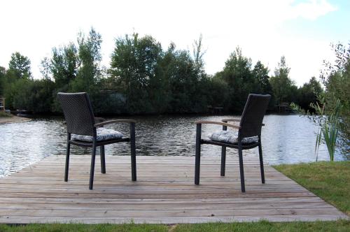 two chairs sitting on a wooden dock near the water at Kleiner Onkel in Twist