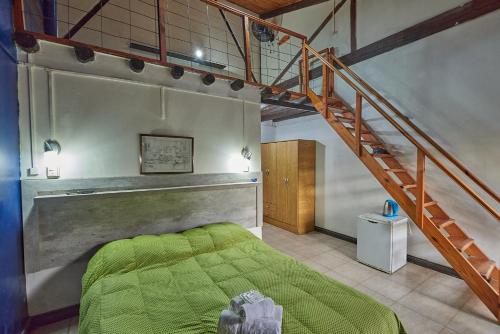 Un dormitorio con una cama verde y una escalera en El Molino - Complejo Turístisco en Victoria