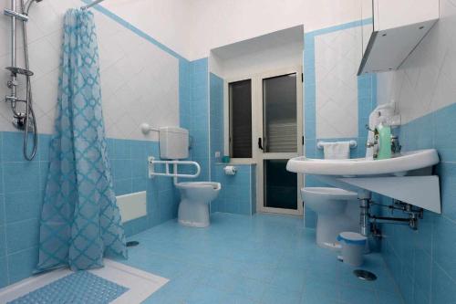 a blue bathroom with a sink and a toilet at Nido Pompeiano Casa Vacanze in Pompei