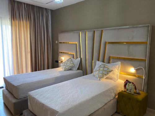 um quarto de hotel com duas camas e uma janela em Marchica Med atalayon em Nador