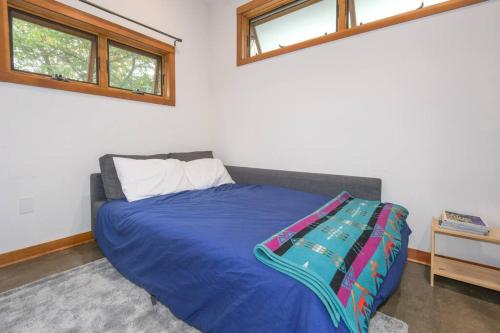 a bedroom with a bed with a blue blanket at Private Studio, Lofted Bed, Soaking Tub & Patio in Portland