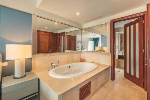 a bathroom with a sink and a large mirror at NEW 2BR Apt w Jacuzzi Punta Palmera CBA in Punta Cana
