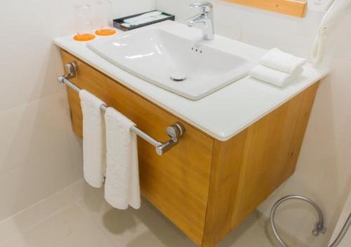 a bathroom with a sink and white towels at Pelyang Boutique in Thimphu
