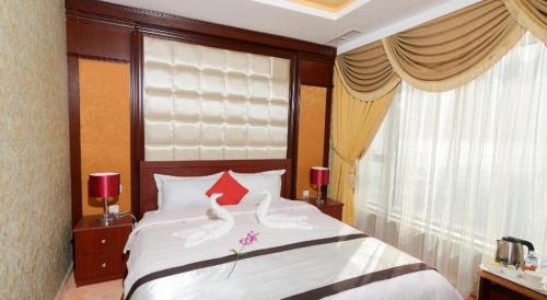 a bedroom with a large white bed with red pillows at Relax inn Apartment - Fahaheel in Kuwait