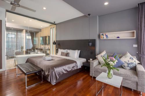 een hotelkamer met een bed en een bank bij X10 Seaview Suites at Panwa Beach in Panwa Beach