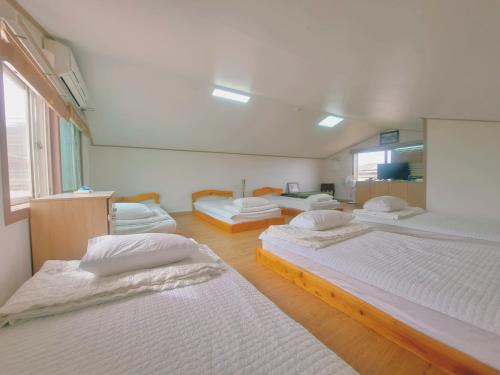 Ένα ή περισσότερα κρεβάτια σε δωμάτιο στο Jeju Gillime Pension