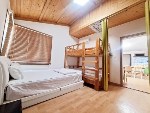 1 dormitorio con litera y escalera en Jeju Gillime Pension en Jeju