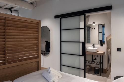 a bedroom with a bed with a mirror and a sink at Houmi Orzán in A Coruña