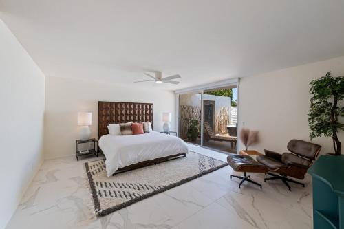 um quarto branco com uma cama e uma cadeira em Tranquil & Spacious, Newly Updated,great Location em Indian Wells