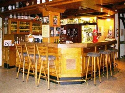 a bar with wooden bar stools in a restaurant at Landhotel Spessartruh in Frammersbach