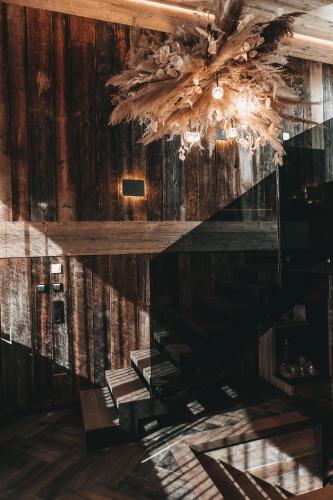 a dining room with a chandelier and wooden walls at Jufenalm BOHO & Wellnesshotel in Maria Alm am Steinernen Meer