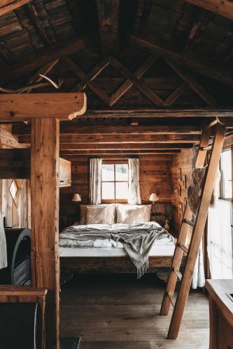 a bedroom with a bed in a wooden cabin at Jufenalm BOHO & Wellnesshotel in Maria Alm am Steinernen Meer