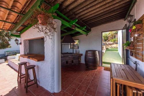 una cocina al aire libre con mesa y barra en Finca con impresionantes vistas, en Los Realejos