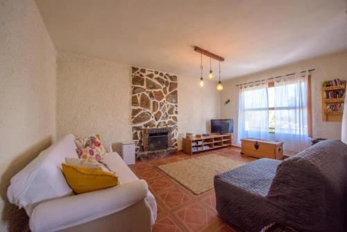 sala de estar con sofá y chimenea en Finca con impresionantes vistas, en Los Realejos