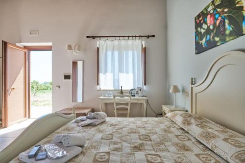 1 dormitorio con 1 cama con toallas en LA MASSARÌA agriresort, en Orta Nova