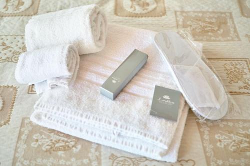 a white towel with towels and a razor and a comb at LA MASSARÌA agriresort in Orta Nova