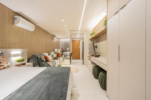タマンダレーにあるFLAT 210 - ECORESORT PRAIA DOS CARNEIROSのベッドとリビングルームが備わるホテルルームです。
