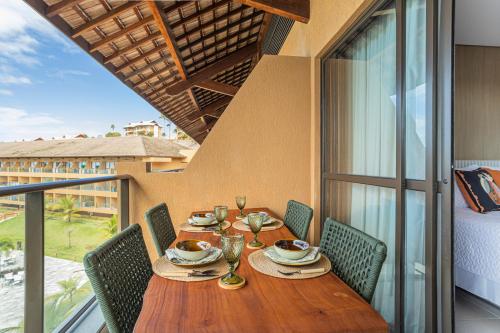 uma mesa de jantar com cadeiras e uma mesa com vista em FLAT 210 - ECORESORT PRAIA DOS CARNEIROS em Tamandaré