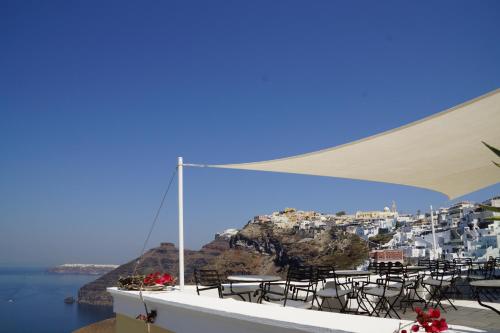 a table and chairs with a view of a city at Cori Rigas Suites in Fira