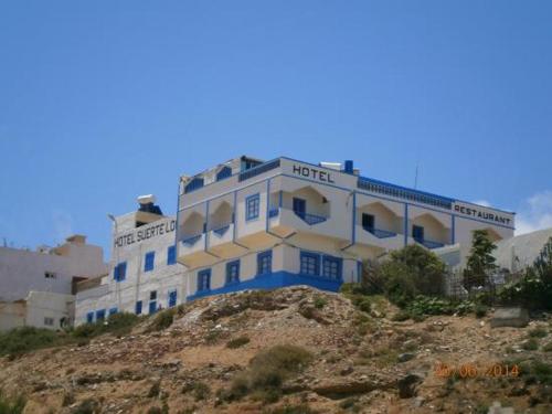 a white and blue building on top of a hill at Suerte Loca in Sidi Ifni