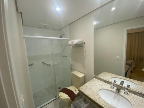 a bathroom with a shower and a sink and a toilet at Bienal First Class Flat Service - UH607 in São Paulo