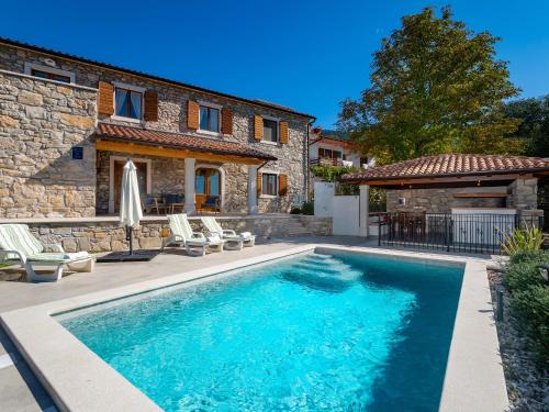 a swimming pool in front of a house at VillaNuova in Šušnjevica