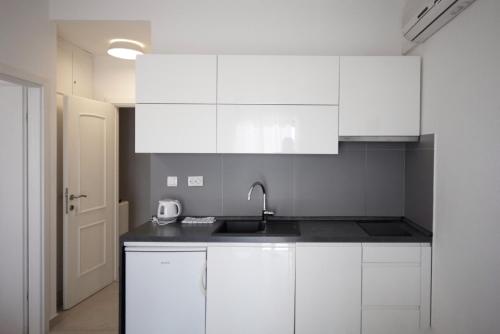 a kitchen with white cabinets and a sink at Guest House Marija in Bol
