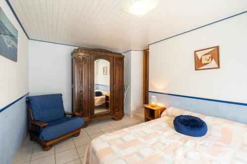 een slaapkamer met een bed, een stoel en een spiegel bij Maison d'une chambre avec jardin clos a Beuzec Cap Sizun a 5 km de la plage in Beuzec-Cap-Sizun