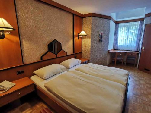 a bedroom with a large white bed and a desk at Landrasthaus Maria Bild in Maria Bild