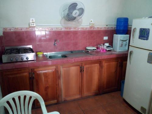 a kitchen with a sink and a refrigerator at Hostal Miconia in Puerto Ayora