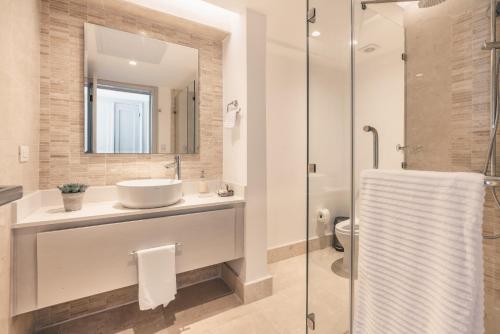 a bathroom with a sink and a glass shower at Ocean view Punta Palmera Studio GC5 in Punta Cana