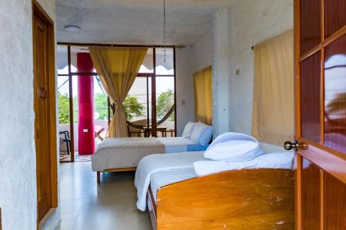 A bed or beds in a room at Royal Galápagos Inn