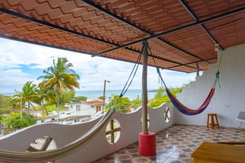 a room with a hammock and a view of the ocean at Royal Galápagos Inn in Puerto Baquerizo Moreno