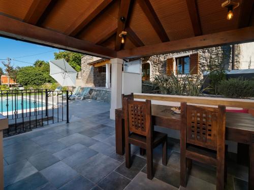 a patio with a table and chairs and a pool at VillaNuova in Šušnjevica