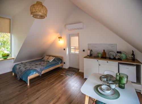 ein Schlafzimmer mit einem Bett und einem Tisch in einem Zimmer in der Unterkunft Vakaras cozy apartment in the guest house with the terrace and the stunning view to the river side in Birštonas