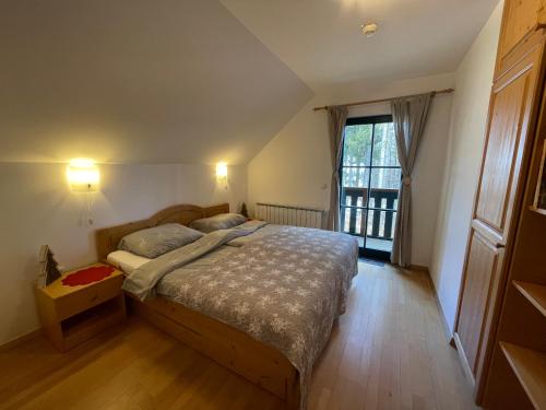 a bedroom with a bed and a large window at Chalet ANRA Pohorje in Zgornje Hoče