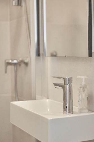 a bathroom sink with a faucet and a mirror at Guest House Marija in Bol