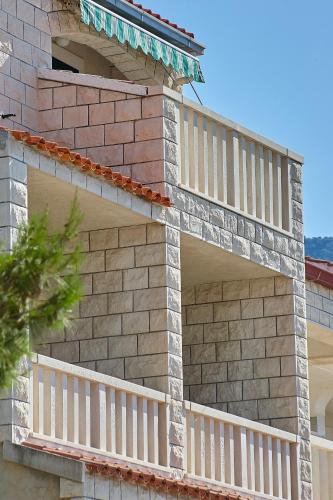 a brick house with white railings on it at Guest House Marija in Bol
