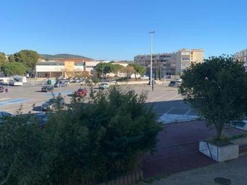un parking avec des voitures garées sur un parking dans l'établissement Appartement cosy avec balcon, proche des Thermes, animaux admis, climatisation et Wifi inclus - FR-1-503-128, à Balaruc-les-Bains